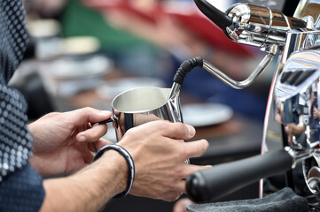 Detail of hand, glass and freshly roasted coffee.