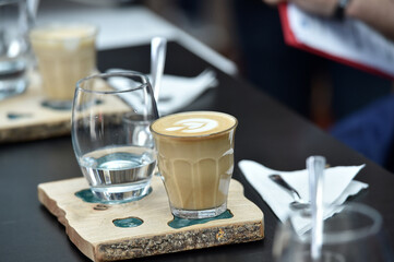 Detail of hand, glass and freshly roasted coffee.