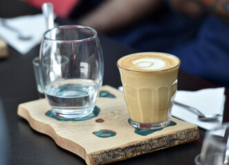 Detail of hand, glass and freshly roasted coffee.