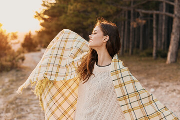 A charming traveler in warm clothes followed on her shoulders and a forest in the background