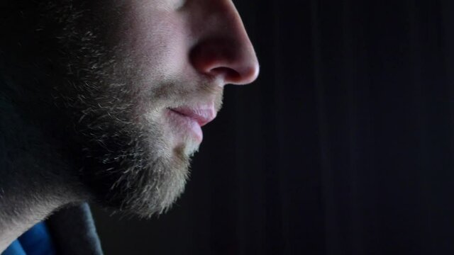 Bearded Caucasian Man Drinking Beer from Pint Glass on Dark Background