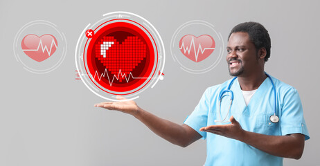 Male African-American cardiologist and red hearts on grey background