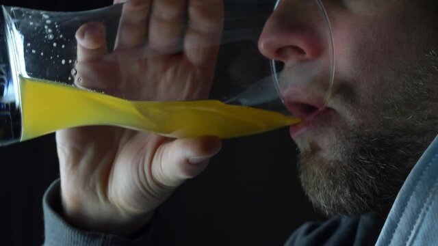 Bearded Caucasian Man Takes off Protective Mask to Drink Beer from Pint Glass