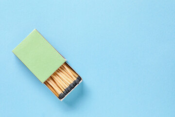 Box with matches on color background