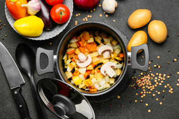 Vegetables in cooking pot on dark background
