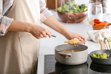 Woman cooking pasta in kitchen