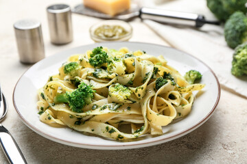 Plate with delicious pasta and broccoli on light background, closeup