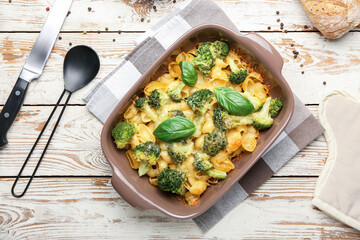 Tasty baked pasta with broccoli and cheese in baking dish on table