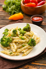 Tasty pasta with vegetables on wooden background