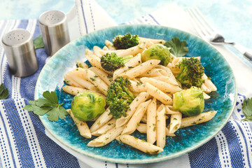 Tasty pasta with broccoli and Brussels sprouts on table