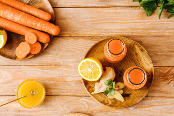 Fresh carrot juice, vegetables and honey on table