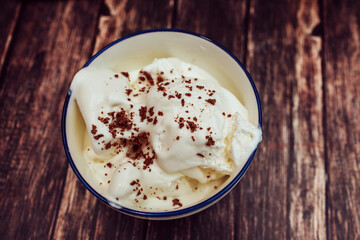 White ice cream in a plate with grated chocolate top view