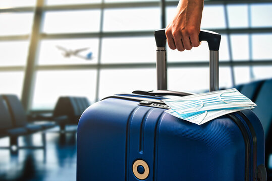 Air Or Airplane Travel During Pandemic Concept With Hand Luggage And Masks In An Airport Terminal