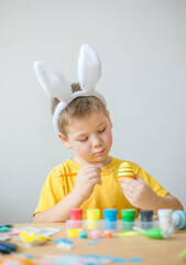 Little kid boy painted  easter egg. DIY  for easter holidays with kids.  Craft for spring