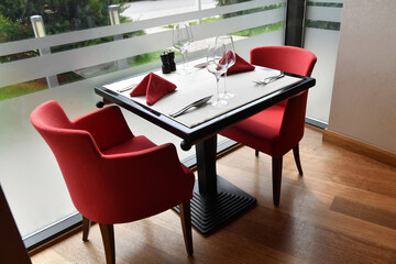 Dinner in a cafe waiting for its customers with red chairs.