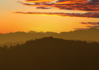 Distant hills during sunset, many layers of depth and color, from greys to orange, the place is the rolling hills in Chiba, Japan