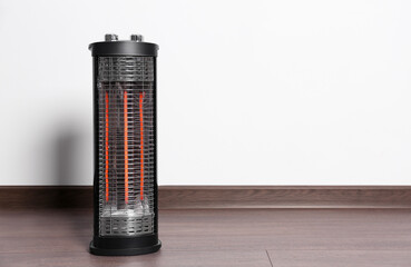 New modern electric heater on floor in room, space for text