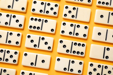 Classic domino tiles on yellow background, flat lay