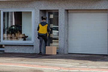 delivery man waiting in front of closed home door rang the bell and watch for customer to open and recieve ordered package box