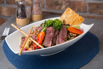 Roast beef salad with baby corn, walnut, pepper and greens 