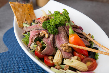 Roast beef salad with baby corn, walnut, pepper and greens 