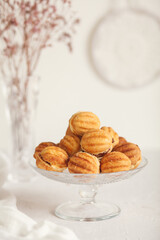 Russian traditional homemade cookies Nuts with condensed milk on a glass stand. White background, selective focus