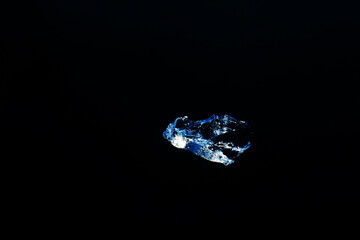 A shard of ice on a dark background of a frozen river. Flat lay of the frame. Copy space