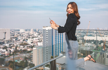 Portrait of smiling pretty young business woman using phone on office background.Fashion Office Clothes Talking On Phone While Standing Outdoors.
