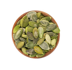 Pumpkin seeds in wooden bowl, isolated on white background. Green pepita seeds. Top view.