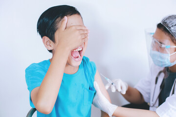 Boy screaming because of pain when being in vaccine injection, injections phobia. Medicine, vaccination, immunization and health care concept