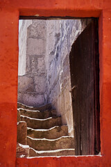 An old open door leading to an ascending staircase, with a red frame, Arequipa, Peru