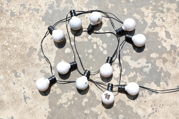 Old bulbs are arranged in different ways on the cement floor. 