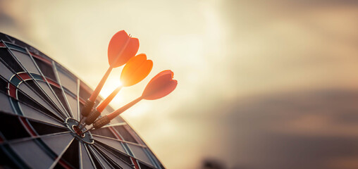 Close up shot of the dart arrow hit on bulleyes of dartboard to represent that the business reached the target  with dark tone picture style. Target and goal as concept. © kunakorn