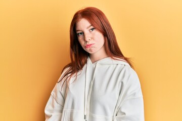 Young red head girl wearing casual sweatshirt depressed and worry for distress, crying angry and afraid. sad expression.