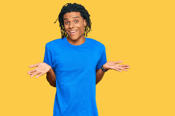 Young african american man wearing casual clothes clueless and confused expression with arms and...