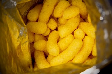 Baked puff corn snacks inside packet. Snacks made up of corn ingredient filled in a packet bag.