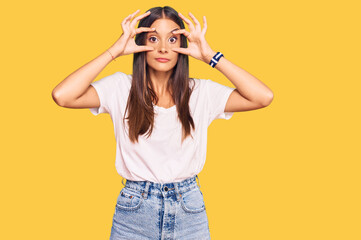 Young hispanic woman wearing casual white tshirt trying to open eyes with fingers, sleepy and tired...