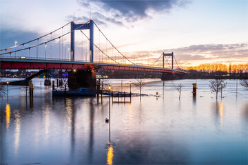 Fototapeta premium Friedrich-Ebert-Brücke über den Rhein in Duisburg am Abend und bei Hochwasser