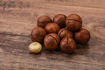 Brown macadamia nut heap over background
