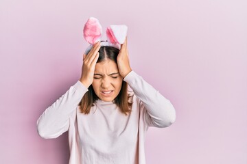 Young beautiful woman wearing cute easter bunny ears suffering from headache desperate and stressed...