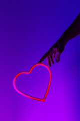 Human forefinger touches neon heart innovative technologies. Mixed media.Love concept.Valentine celebration