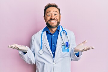 Middle age man wearing doctor uniform and stethoscope clueless and confused expression with arms...