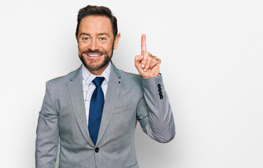 Middle age man wearing business clothes showing and pointing up with finger number one while smiling confident and happy.