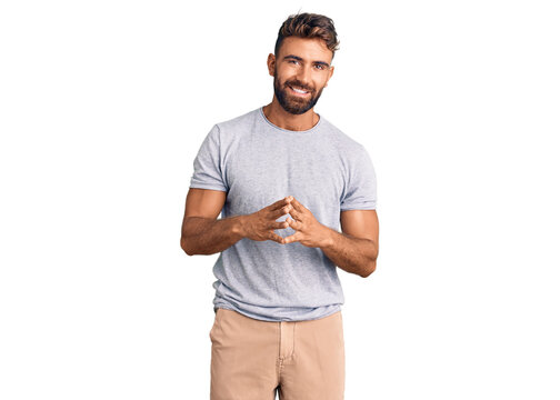 Young hispanic man wearing casual clothes hands together and fingers crossed smiling relaxed and cheerful. success and optimistic