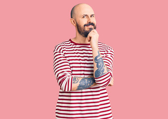 Young handsome man wearing casual clothes looking confident at the camera with smile with crossed arms and hand raised on chin. thinking positive.