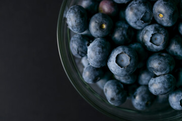 Bowl of blueberries on black background. Macro photography of fresh blueberries. Ripe blueberries background. Blueberries texture. Food photography collection.