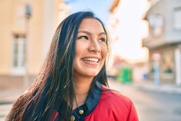 Fototapeta premium Young latin woman smiling happy walking at the city.