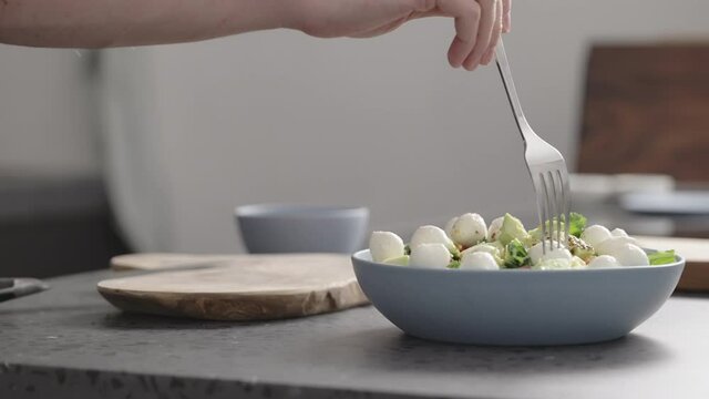 Slow motion man eat salad with kale, mozzarella, avocado and cherry tomatoes