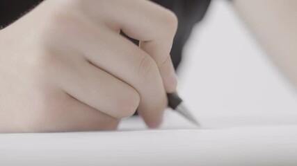 Close-up shot of a hand seen scribbling something on a large sheet of paper, most likely a technical concept of some kind. The camera is rotating around the drawer's hand in a half circle.