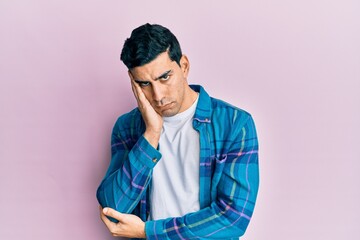 Fototapeta premium Handsome hispanic man wearing casual clothes thinking looking tired and bored with depression problems with crossed arms.